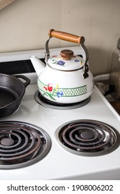 A Vintage Stovetop In A White Walled Kitchen.