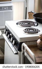 A Vintage Stovetop In A White Walled Kitchen.