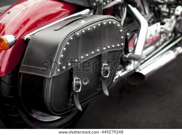 Vintage\
studded leather bag on a cool red\
motorcycle.