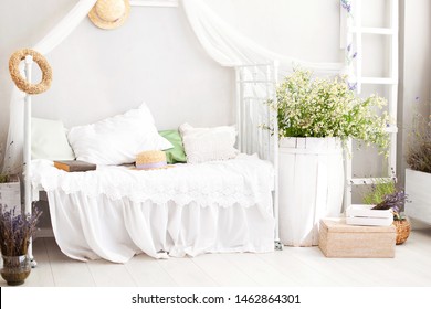 Vintage studio apartment interior in light colors in old style. Shabby white chic bedroom interior for a country house. Interior items in Provence. bouquet of field daisies in the bedroom. Village