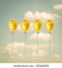 Vintage style 2016 gold color balloon in golden egg up side down shape floating in the cloudy sky 