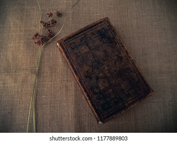 Vintage Style. Closed Antique Book With Dry Grass And Red Thread With Burlap Background