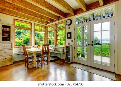 Vintage Style Dining Room With Large Wood Beams And Glass Door.Wood Beam Ceiling And Hardwood Floor. 