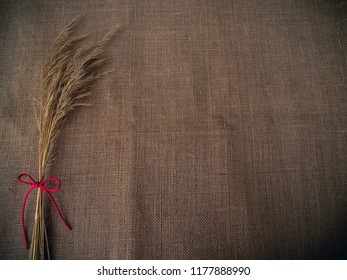 Vintage Style. Dry Grass And Red Thread With Burlap Background