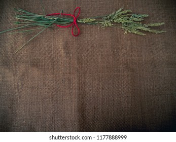 Vintage Style. Dry Grass And Red Thread With Burlap Background