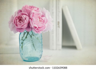 Vintage style photograph of a bouquet of pink English roses in a turquoise blue mason jar - Powered by Shutterstock