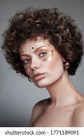 Vintage style portrait of young beautiful woman with curly hair and fancy makeup