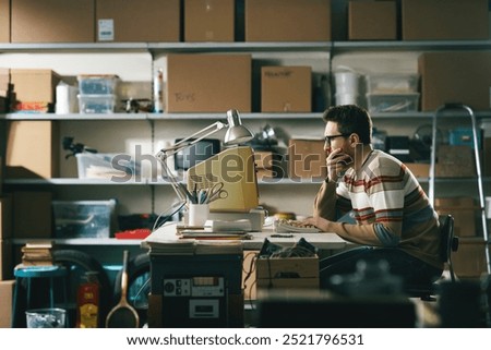 Vintage style programmer sitting at his desk and working with an old PC in his basement at home
