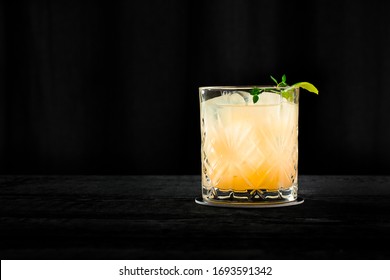 Vintage Style Whisky Sour, Orange Cocktail On The Black Background
