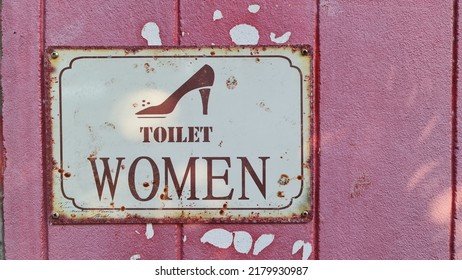 Vintage Style White Women's Restroom Sign On A Pink Bathroom Wall.