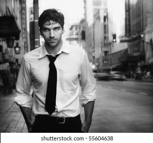 Vintage Stylized Black And White Photo Of Young Male Model Against City Street (Photo Has An Intentional Film Grain)