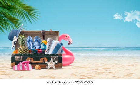 Vintage suitcase with colorful summer accessories at the tropical beach, summer vacations concept, copy space - Powered by Shutterstock