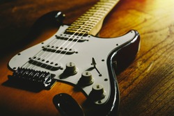 Vintage Sunburst Color Guitar With Old Wood Surface In Background.