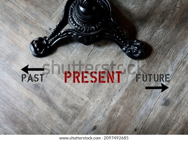 Vintage table on wood floor with text PAST\
PRESENT FUTURE, focus only PRESENT, concept of live with the moment\
- be with the NOW, control anxiety - not to worry about yesterday\
or tomorrow