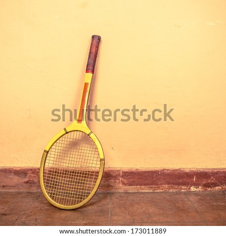 Vintage tennis racket against a wall