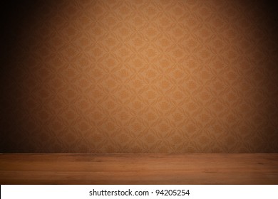 Vintage textured brown wallpaper with heavy vignetting over a wooden floor, empty with copyspace.