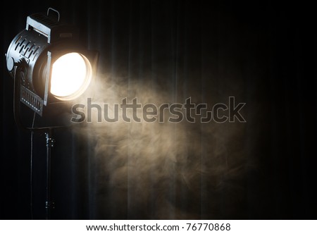 vintage theater spot light on black curtain with smoke