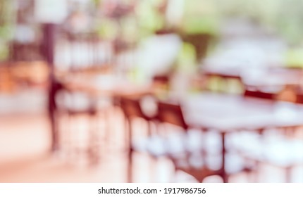 Vintage Tone Abstract Blur Image Of  Outdoor Restaurant  In Garden With Green Bokeh For Background Usage .