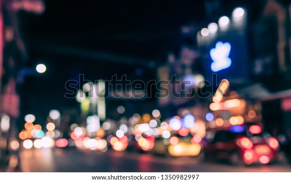 Vintage tone abstract blurred image\
of Road in night time with light bokeh  for background\
usage.