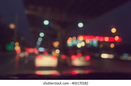 Vintage Tone Blur Image Of Inside Cars With Bokeh Lights From Traffic Jam On Night Time For Background.