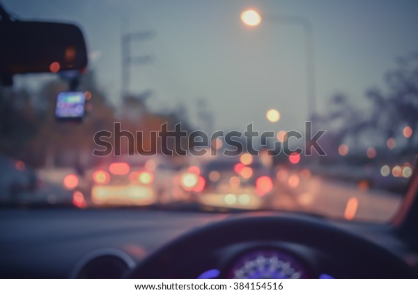 vintage tone blur image of
people driving car on day time for background usage.(take photo
from inside)