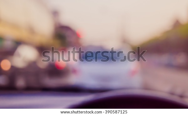 vintage tone blur image of
people driving car on day time for background usage.(take photo
from inside)