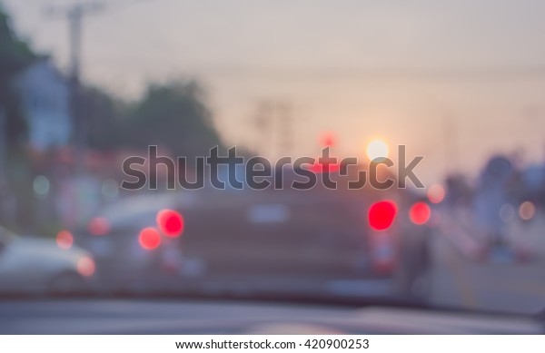 vintage tone\
blur image of people driving car on evening time for background\
usage.(take photo from\
inside)