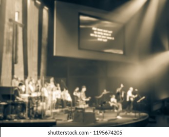 Vintage Tone Blurry Abstract Worship Band And The Choir At Bible Church In Texas, USA. Dark Background, Smoke, Concert Spotlights For Christian Concept. Worship Lyric Projection