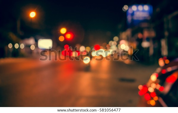 vintage tone image of\
blur street and footpath with colorful lights in night time for\
background usage .