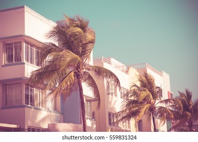 Vintage tone image of palm trees and typical retro art deco style buildings seen from South Beach Miami Florida 