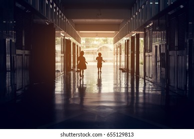 vintage tone silhouette image of kids running in school hall way.
