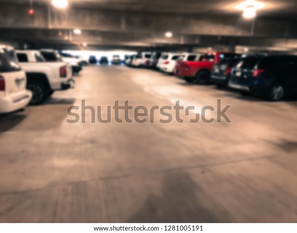 Vintage tone underground parking garage at
American airport. Rows of red and green lights hanging over the
parking spaces show whether or not a parking spot is open. Smart
parking loT guidance
system