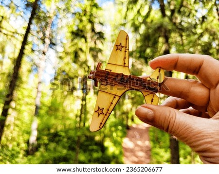 Vintage toy wooden airplane with stars on wing on nature. Plane crash, breakdown. Old Soviet glider from USSR of Soviet Union. Military aircraft from World War II and the Great Patriotic War of Russia