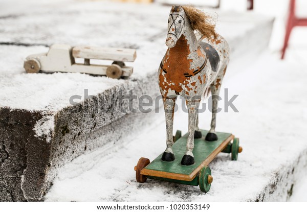 VIntage toys wooden car and wooden  horse on\
the snow background\
