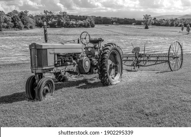 Vintage Tractor And Plow In Field As A Yard Decoration In Black And White