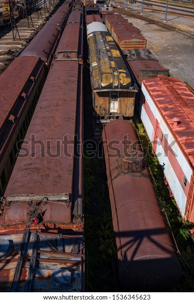 Vintage train cars\
and locomotives, covered in rust and are in disrepair, rest on\
tracks in Scranton, PA, USA.\
