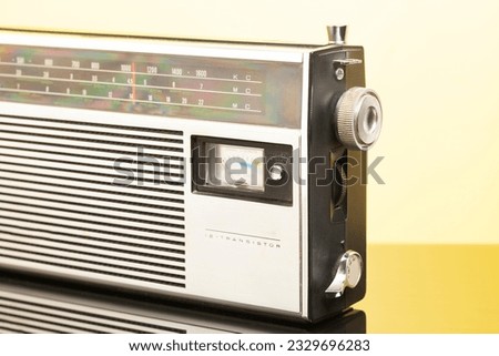 Vintage transistor radio, on yellow background.