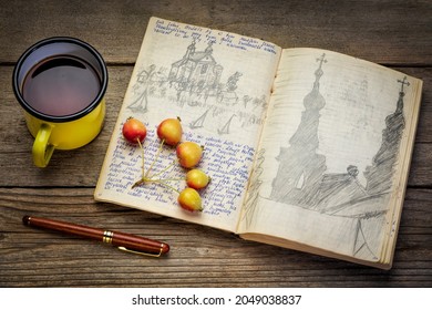 Vintage travel journal with handwriting and pencil sketches (property release attached) on rustic table with tea - kayak expedition in Poland 1970s.