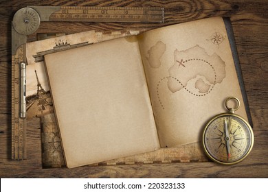 Vintage treasure map in open book with compass and old ruler. Adventure and travel concept.