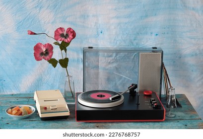 vintage turntable with purple vinyl record, speaker and old cassette tape recorder, seventies still life, with analog film colors