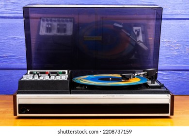 Vintage turntable vinyl record player with blue and orange vinyl on a table - Shutterstock ID 2208737159