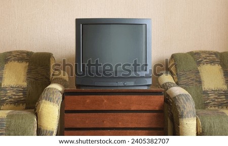 Vintage TV on wooden antique closet, old design in a home.Old black vintage TV. 
