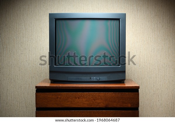 Vintage TV on wooden antique closet, old design in a\
home.Old black vintage\
TV.