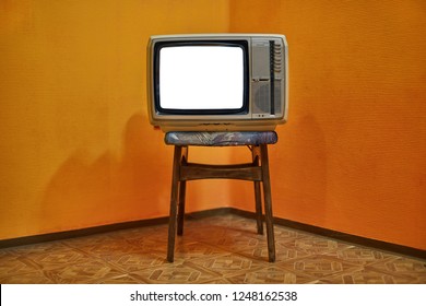 Vintage TV set on a chair in an empty room, blank white screen