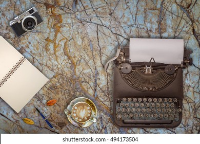 Vintage typewriter, camera and a cup of coffee on marble background - Powered by Shutterstock