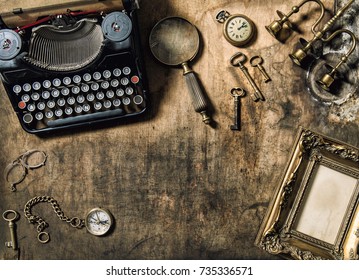 Vintage typewriter, golden frame, old office accessories on wooden table. Still life