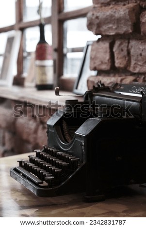 A vintage typewriter on a wooden table illuminated by natural light coming through a nearby window