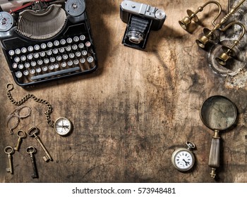 Vintage typewriter, photo camera and old office accessories on wooden table. Nostalgic still life flat lay