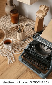 Vintage typewriter with tea and creative tools on wooden desk, cozy workspace for writing and artistic endeavors