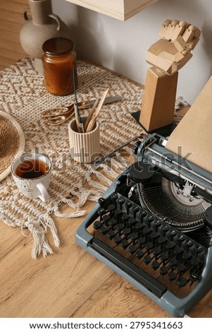 Vintage typewriter with tea and creative tools on wooden desk, cozy workspace for writing and artistic endeavors